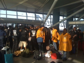 A Szcientológia önkéntes lelkészek és más segélyszervezetek tagjai a New York-i JFK repülőtéren várnak a Haitire tartó gépre.